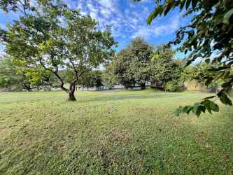 Large vacant residential lot with clear sky and green trees Coronado Panama