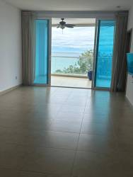 Spacious living with floor-to-ceiling doors opening to oceanfront terrace Santa Clara Amanecer