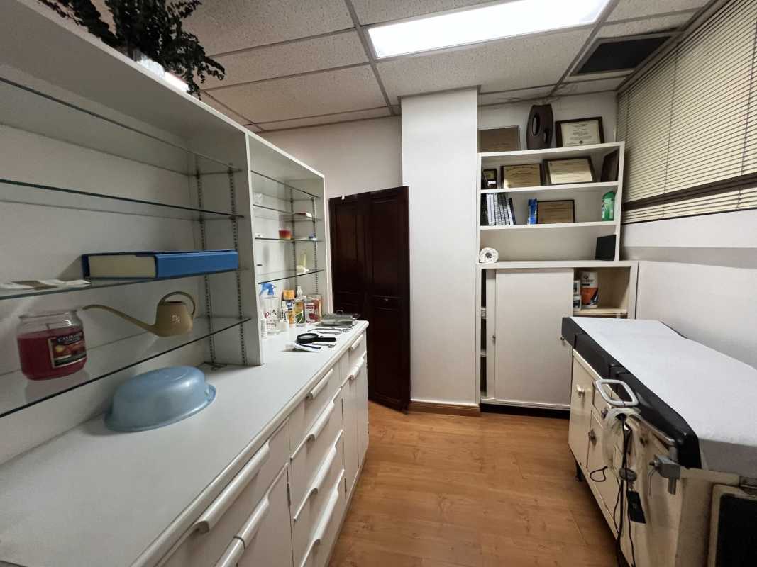 Functional examination room with equipment, built-in storage, glass shelves in Punta Paitilla medical building