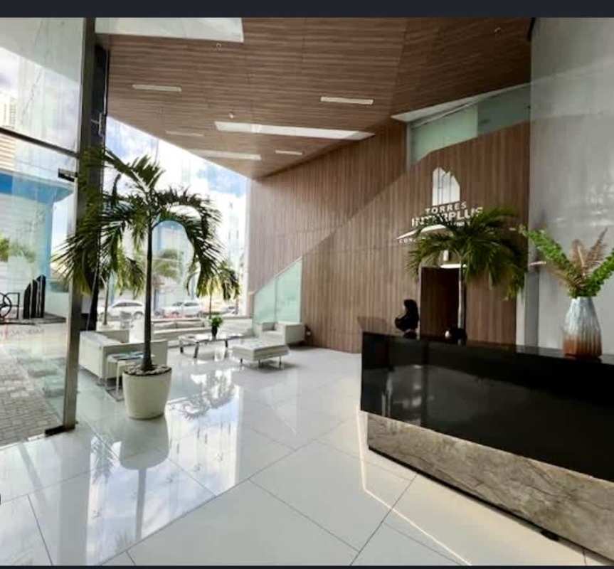 Double height lobby with glass facade, white sofas and plants at Balboa Office Center Panama City