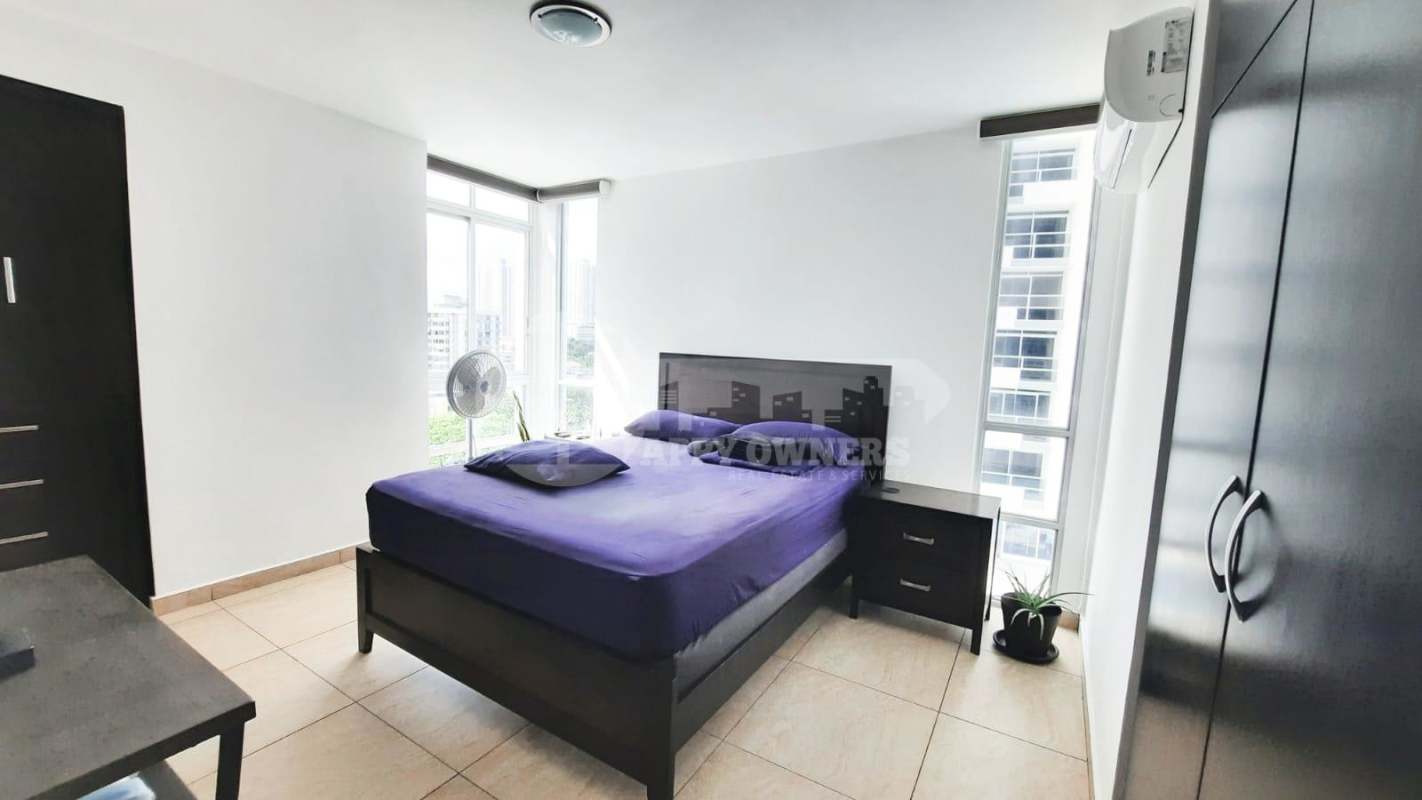 Modern bedroom with built-in closet purple bedding corner windows in PH Vista Park Panama