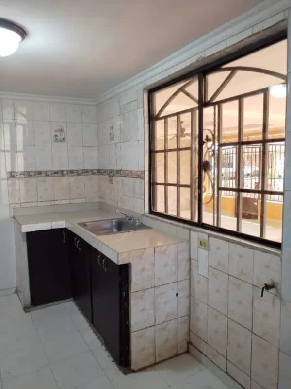 Ceramic tile kitchen with window and cabinets in Don Bosco Panama house