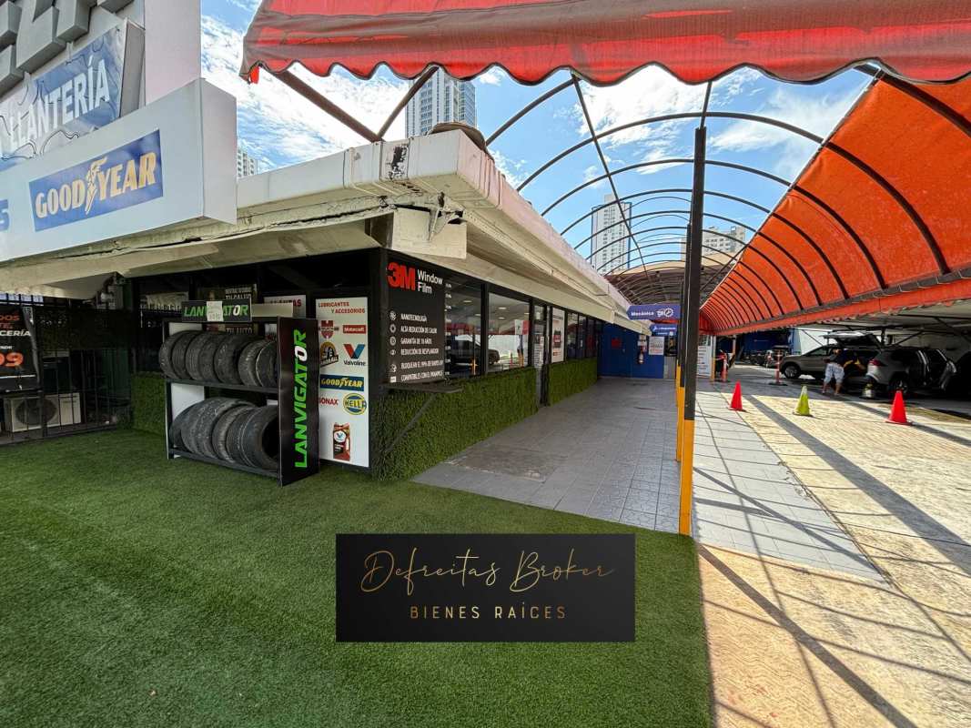 Industrial workshop interior with vehicle lift, paint booth, and car tool stations in San Francisco Panama