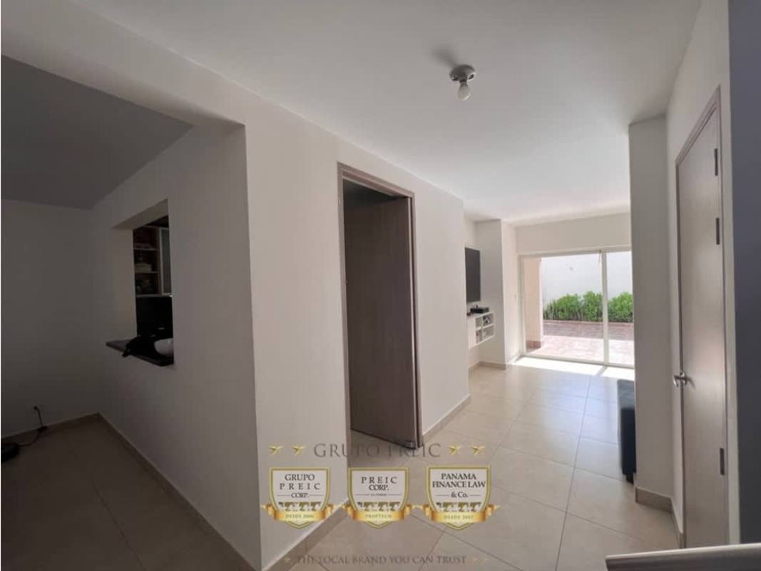 Spacious living room with blue sofas, TV, pendant lights and air conditioning in Reserva de Versalles duplex Panama City