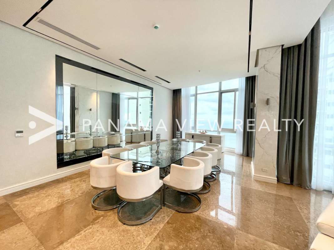 Elegant dining space with floor-to-ceiling windows and water views in PH Blue Bahia penthouse