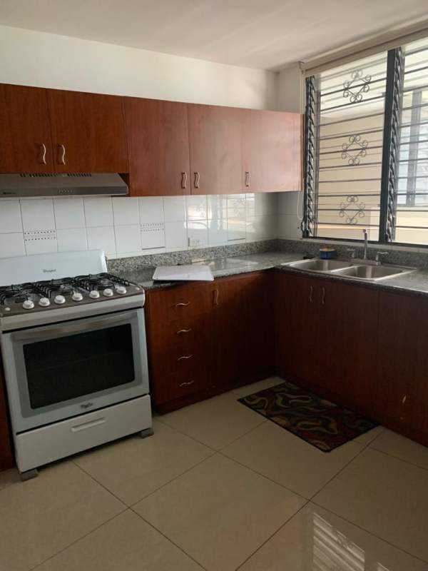 Kitchen with brown cabinets, granite counters, large window with security bars in PH Royal Princess