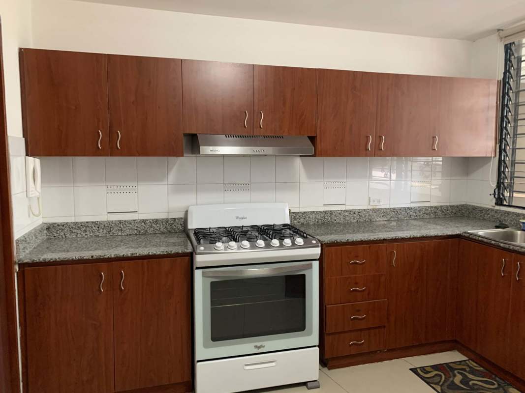 Modern kitchen with granite countertops, stove, and white backsplash in PH Royal Princess