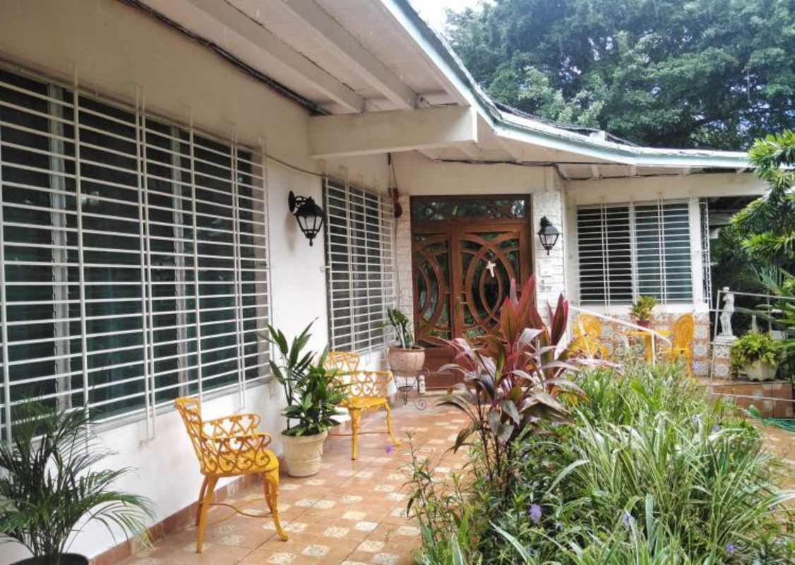 Traditional tropical bungalow entrance with wood doors lush garden Coco del Mar