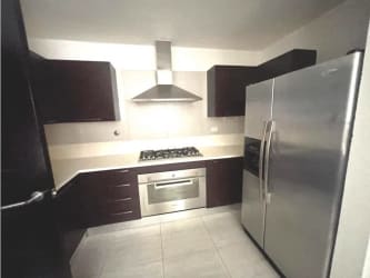 Spacious modern kitchen with granite countertops, cabinets and appliances in PH Nativa Panama Pacifico