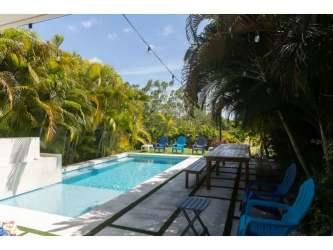 Contemporary floating wood staircase with open kitchen in Casamar beach home