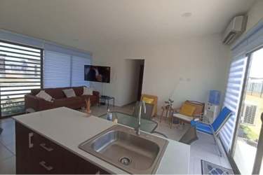 Modern open concept living room with kitchen island, split AC, large windows at Costa Blanca Villas Playa Blanca
