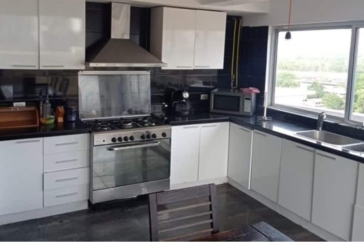 Modern white kitchen cabinets, black counters, large window PH Terrazas La Cresta Bella Vista