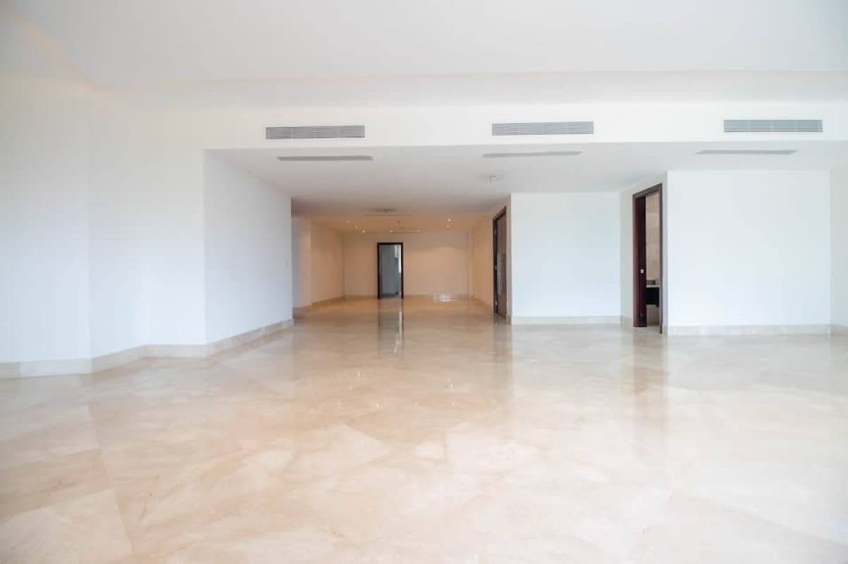 Large marble-floored living room with floor-to-ceiling windows and access to oceanfront balcony in PH Miradores