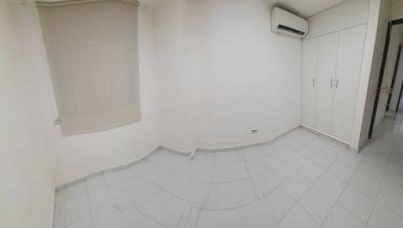 Secondary bedroom with air conditioning split unit, closet, tile floor in Bella Vista apartment for sale Panama