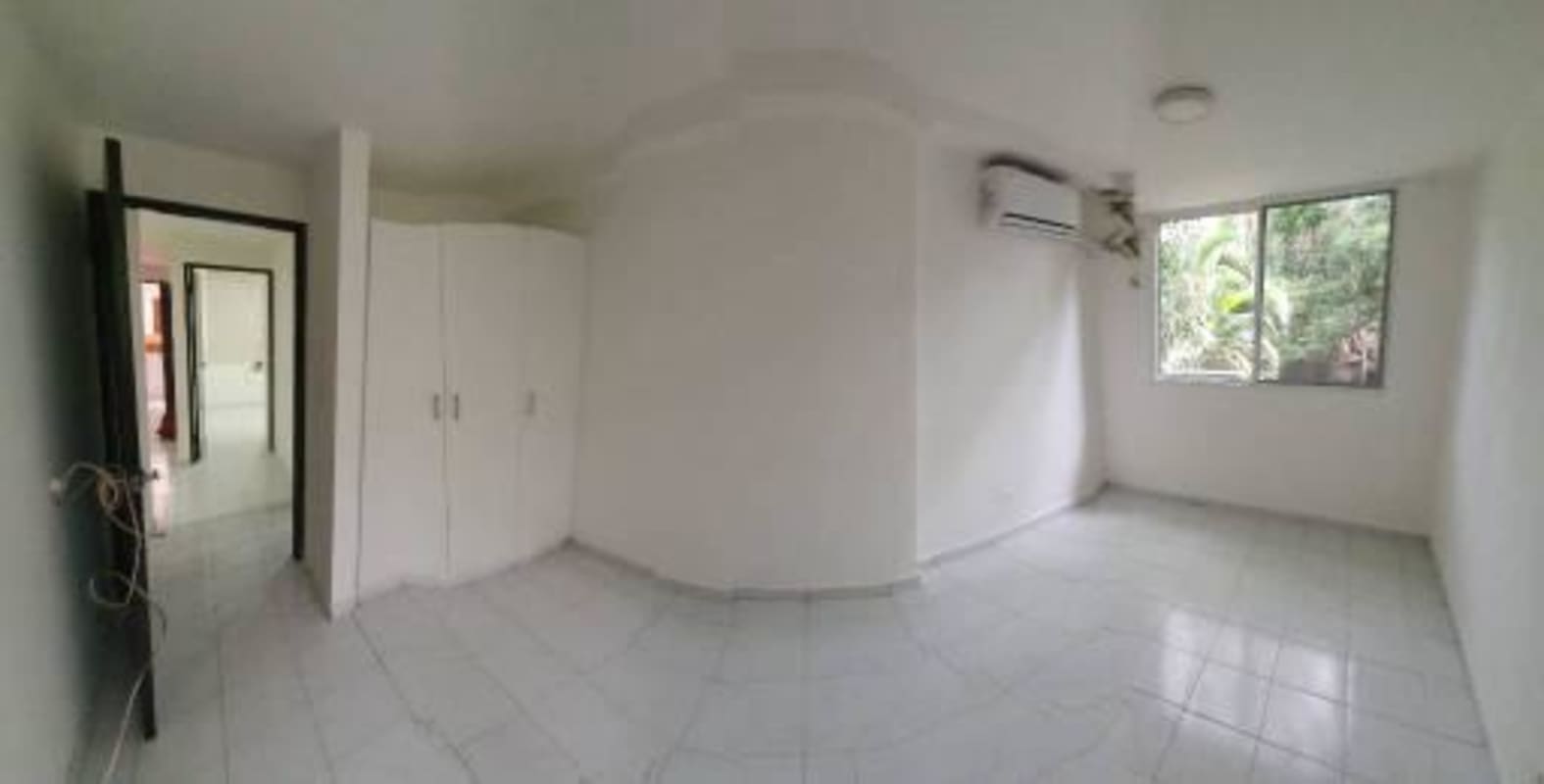 Bedroom with split AC, wardrobe, neutral decor in Bella Vista apartment Panama for sale