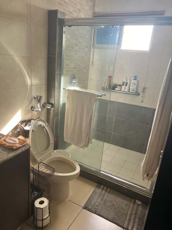 Bathroom with glass shower enclosure tiled walls modern sink PH Dos Mares Panama