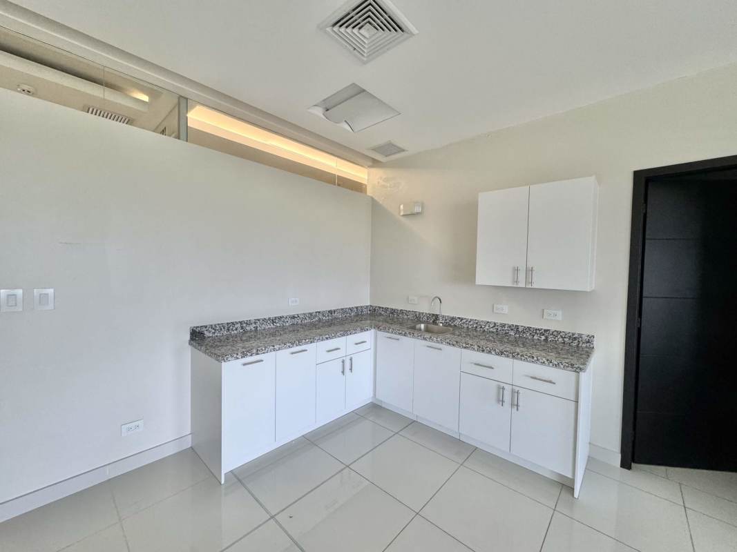 Minimalist kitchen area in corporate office with granite countertops, Costa del Este Panama