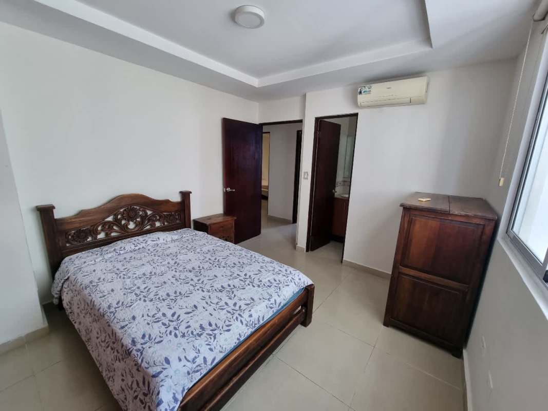 Bedroom with carved wood bed, closet, large window PH Pacific Sea Coco del Mar