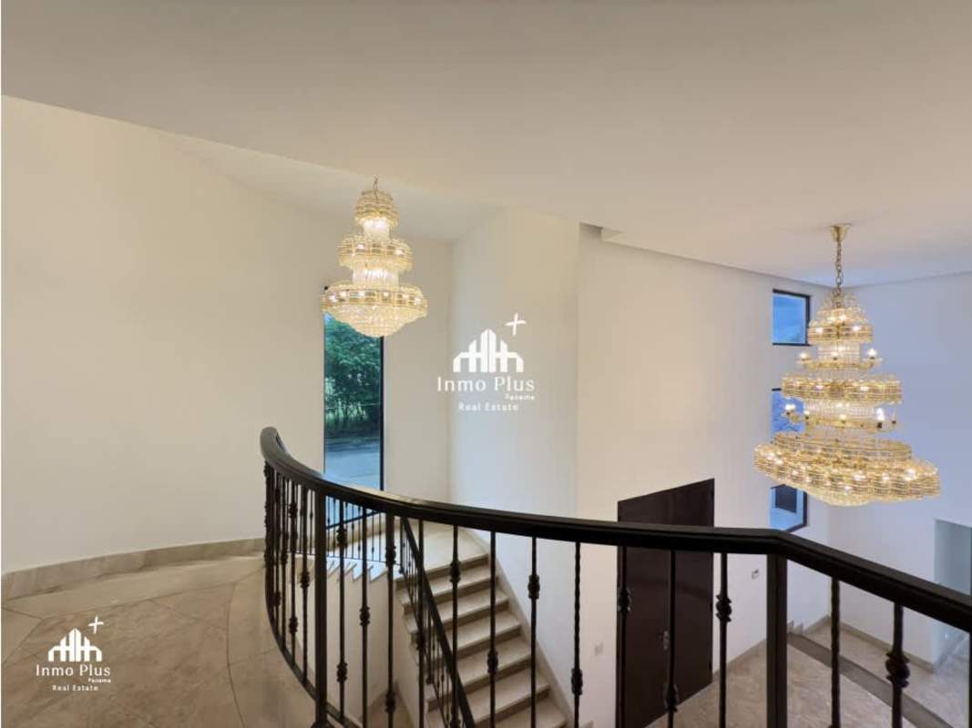 Walk-in closet with dark wood cabinets, central storage island, and built-ins in luxury rental house Costa del Este Panama