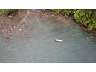 Coastal view with boat and forested shoreline on Panama's Cebaco Island land