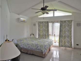 Covered outdoor terrace with seating and mountain views next to pool in Trinity Hills Valley Panama