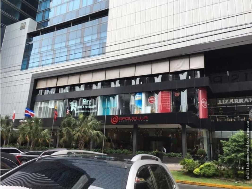 Contemporary glass facade of Sortis Hotel Spa Casino and commercial tower with palm trees in Panama City