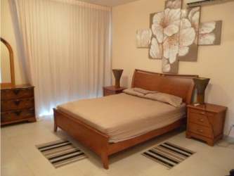 Bedroom with wooden furniture floral art curtains in Playa Blanca Panama