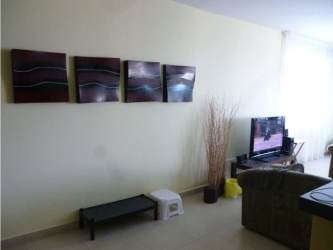 Furnished bedroom in Founders I Playa Blanca with wooden headboard curtains floral wall art Panama