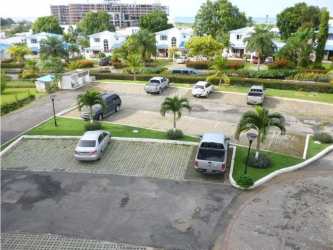 Parking lot in residential Playa Blanca Founders I palm trees white buildings Panama