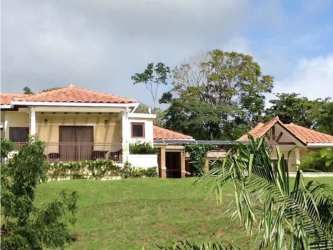 Homes with red tile roofs large windows at Trinity Hills Valley residential community Panama