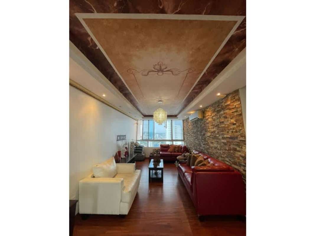 Open modern kitchen with island bar, granite counters and views to Pacific Ocean in penthouse Panama