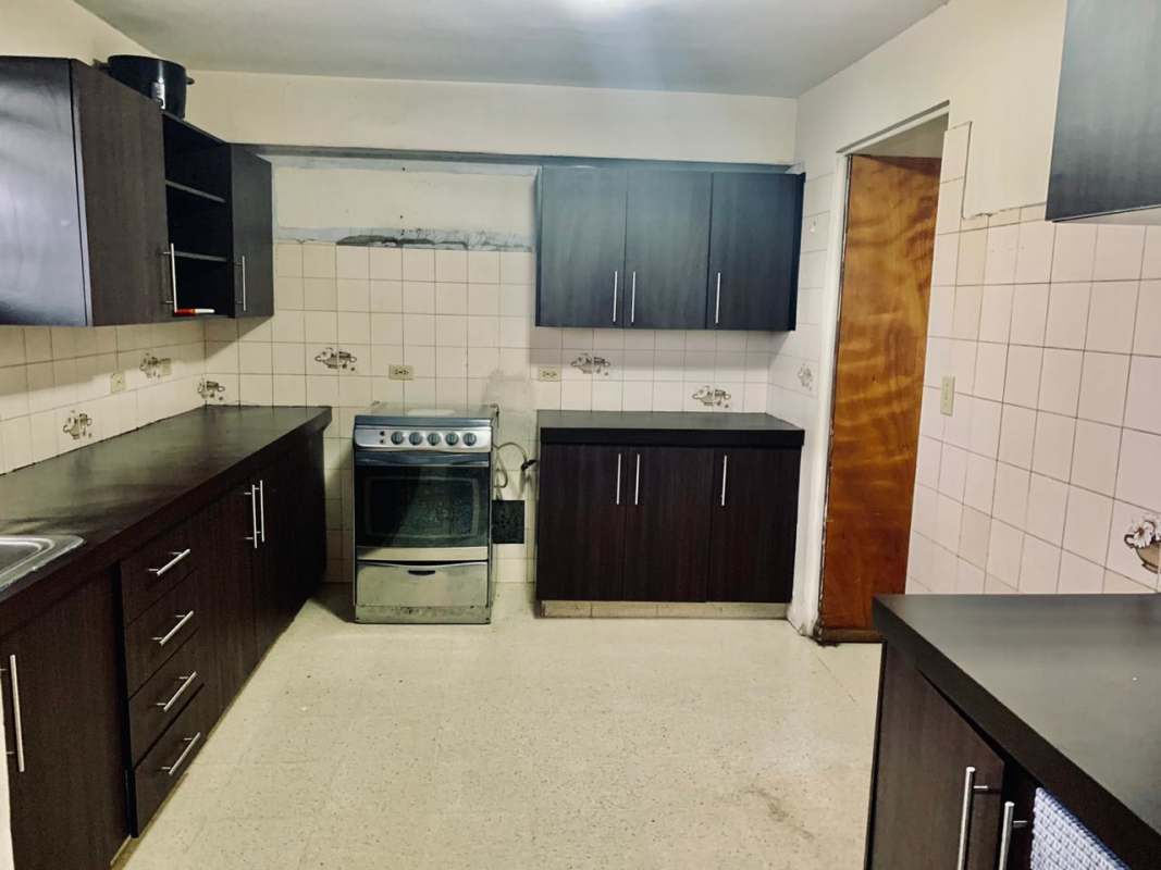 Affordable rental apartment kitchen with stove, cabinets, tile backsplash Panama City