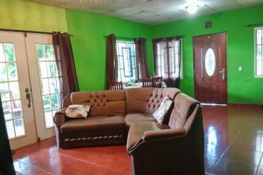 Open plan dining and living space with traditional tile and green walls Chiriquí
