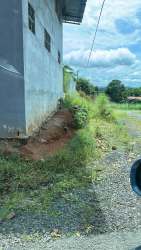 Side view of commercial fenced lot with vegetation and industrial building El Mastranto La Chorrera
