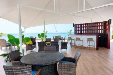 Covered bar area with wicker seating overlooking beach at Malibu Residences Gorgona Panama