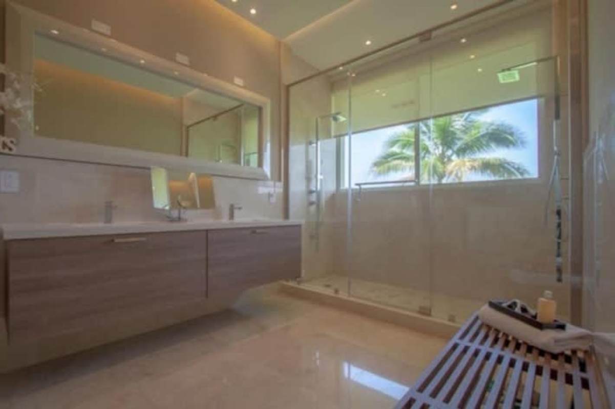 High-end kitchen with granite island, white cabinetry, top appliances and pendant lighting