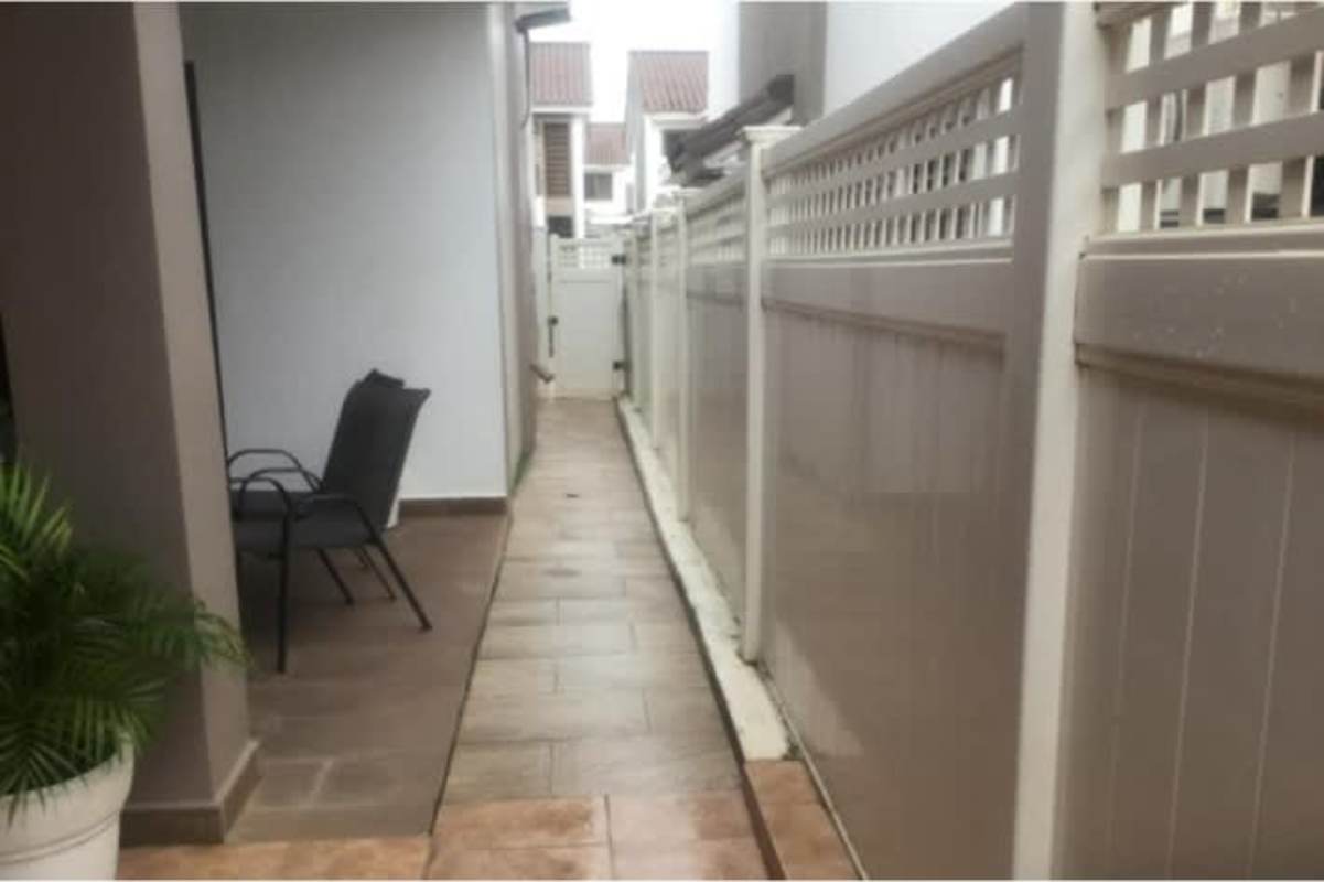 Exterior walkway with covered patio, privacy wall and gate in private Panama home