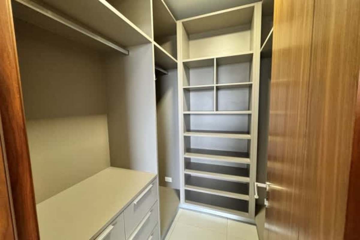 Spacious walk-in closet with built-in shelves and drawers in PH Marbella Tower Panama City