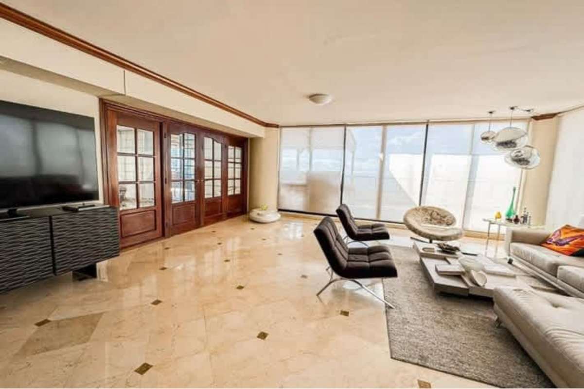 Bright living room with floor-to-ceiling windows and Panama Bay view at PH Condesa del Mar Panama City