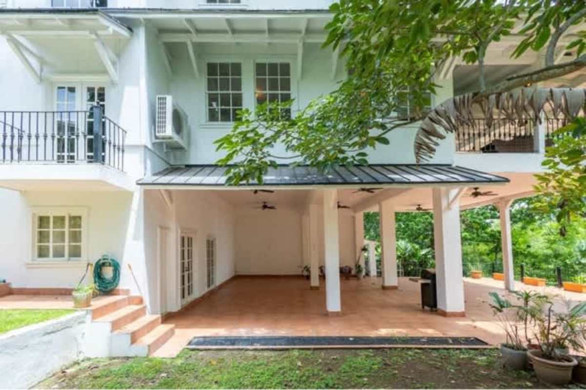 Sunroom with large glass doors, wood flooring and ceiling fans in historic Casa Gorgas Ancón Panama