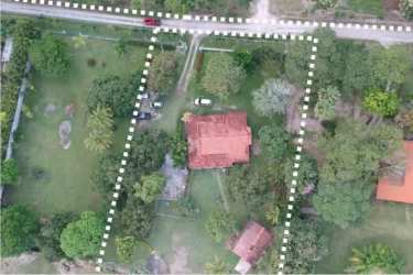 Aerial of fenced acres, house, trees on beachfront development land Bijao Panama