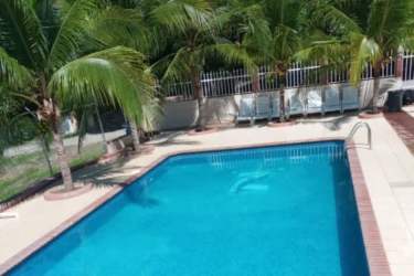 Tropical swimming pool with lounge chairs and palm landscaping in beach estate Panama