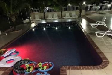 Tropical covered patio lounge area with hammocks overlooking pool in beach house Panama