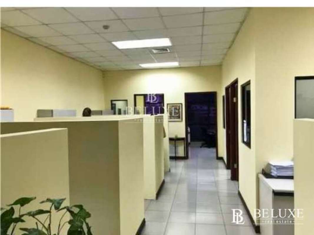 Partitioned office cubicles with fluorescent lighting and tiled floors in PH Mall 50 San Francisco Panama