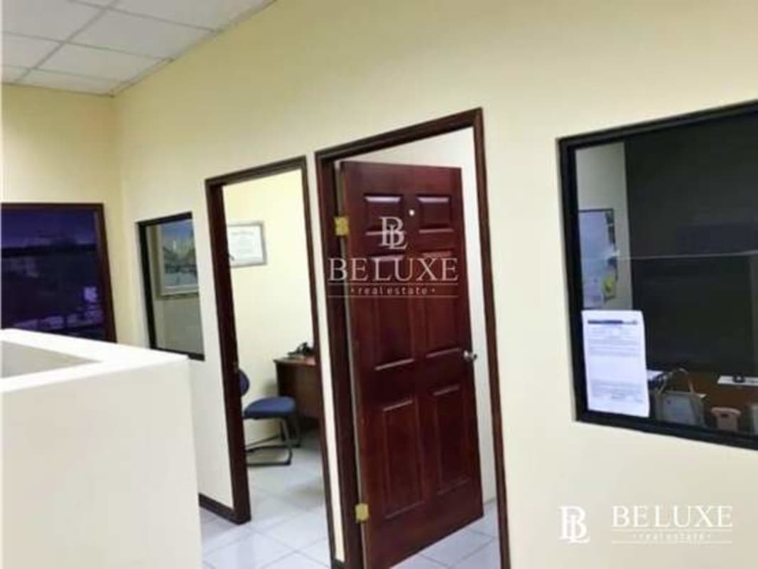 Reception area with desk, blue chairs, and glass sliding door in PH Mall 50 office Panama
