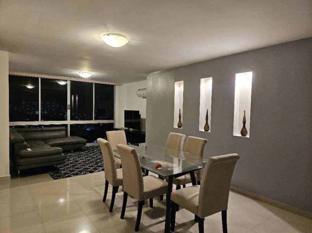 Spacious open concept living and dining room with night skyline view in PH Hato Pintado Tower