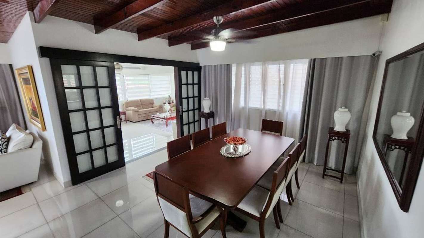 Living room with brown sofas, ceiling fan, large windows with blinds Betania Panama