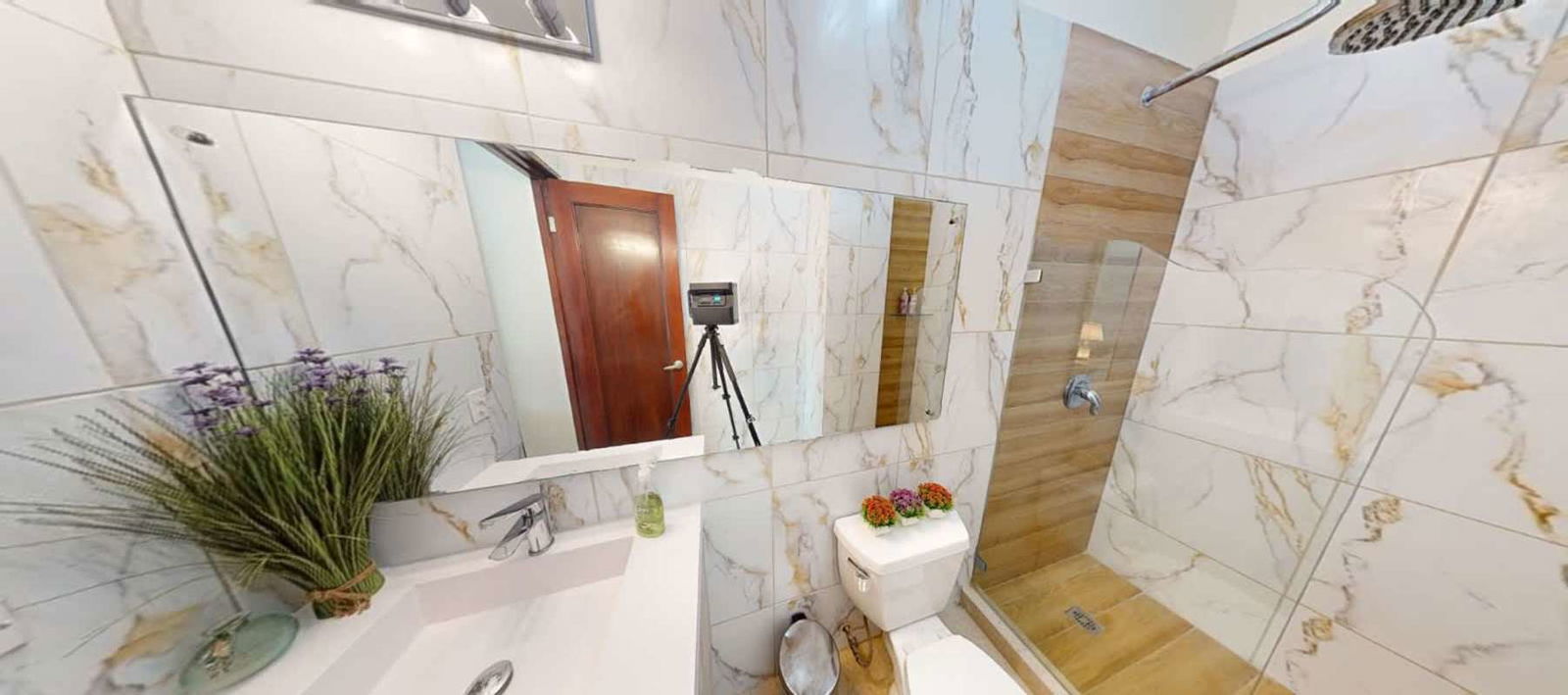 Furnished living room with large glass doors, ocean and city views at PH Amador Hills Panama City