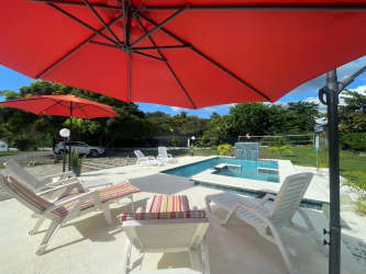 Private pool sun loungers umbrellas green landscaping beach house rental Malibu Gorgona Panama