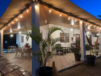 Rustic outdoor covered patio with string lights hammock dining at beach house rental Malibu Gorgona Panama